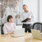 Two colleagues collaborating in a modern office setting.