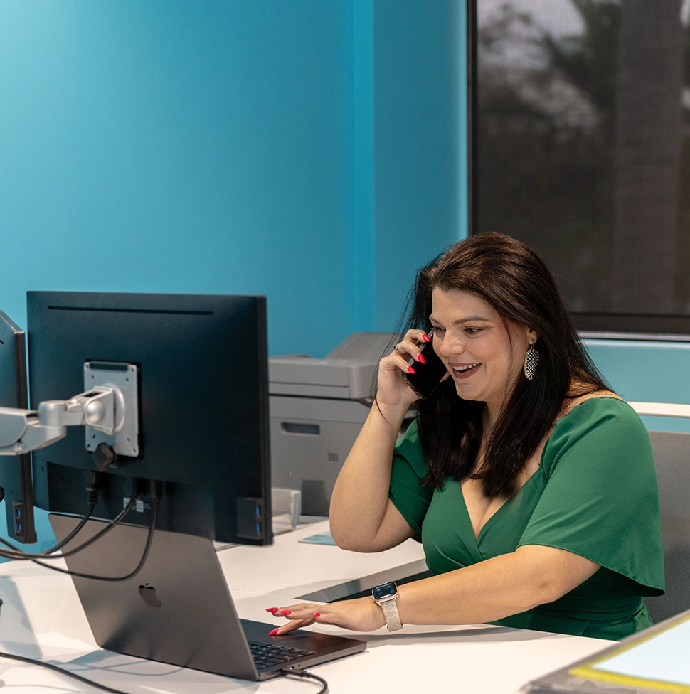 Woman working on computer and phone call.