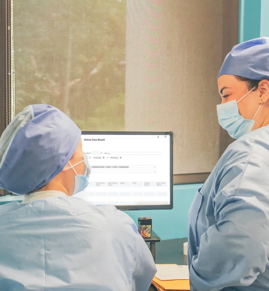 Medical professionals discussing patient information on computer.